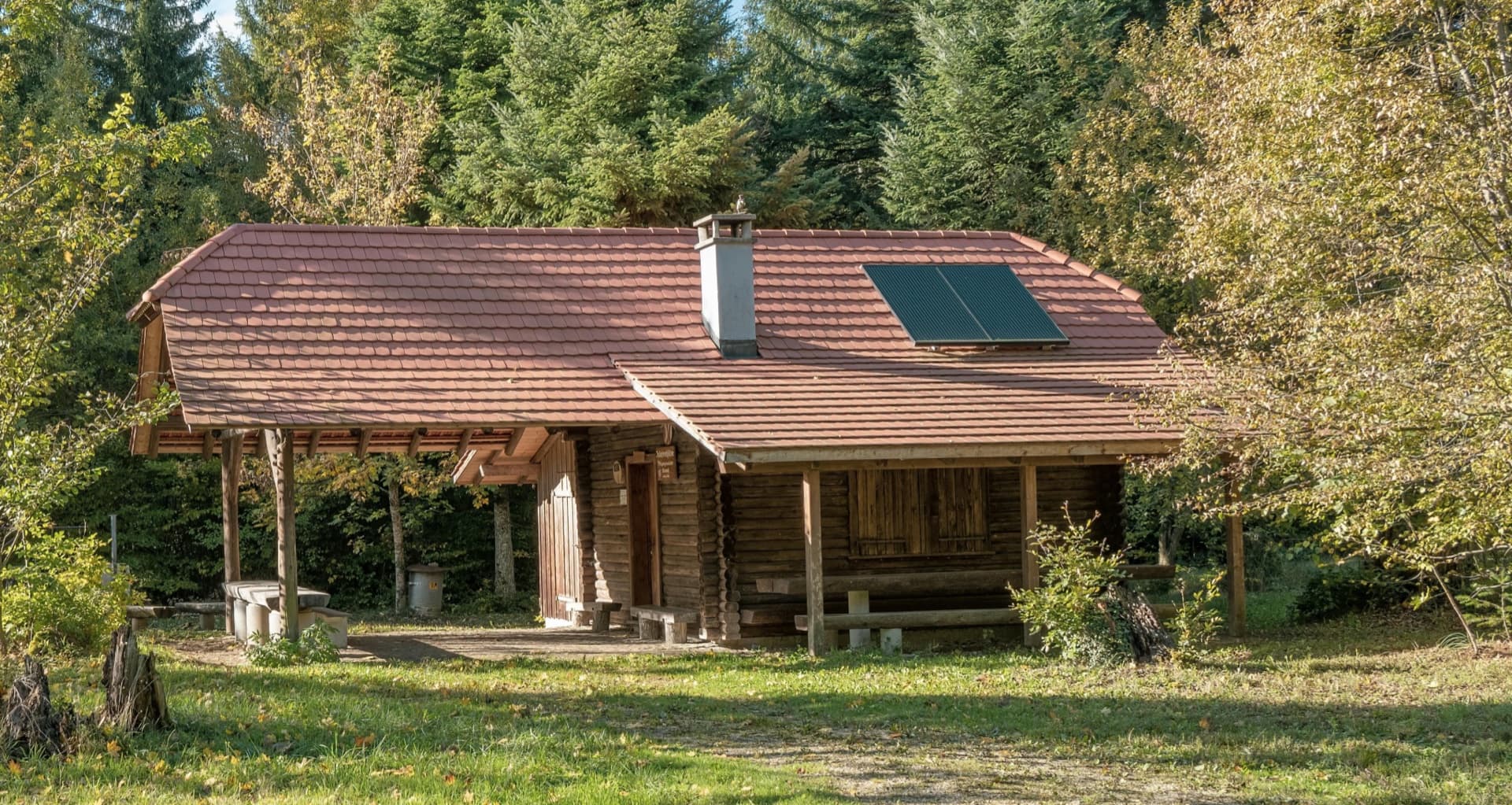 Brvnara u prirodi sa solarnim panelima na krovu — referentni 1.6 kW Off-Grid sistem