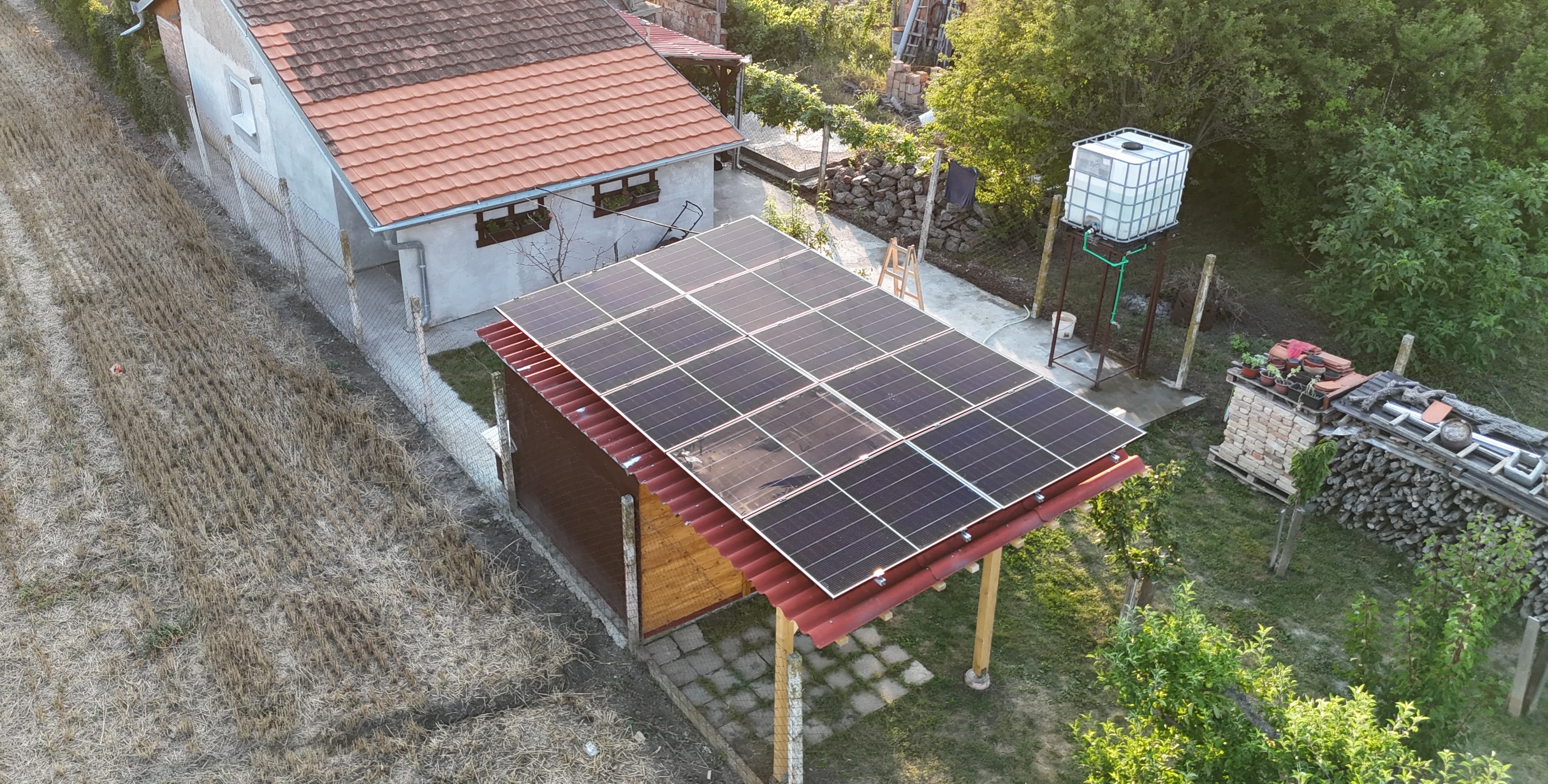 Solarni paneli postavljeni na nadstrešnici pored kuće na imanju — referentni 5 kW On-Grid Premium sistem