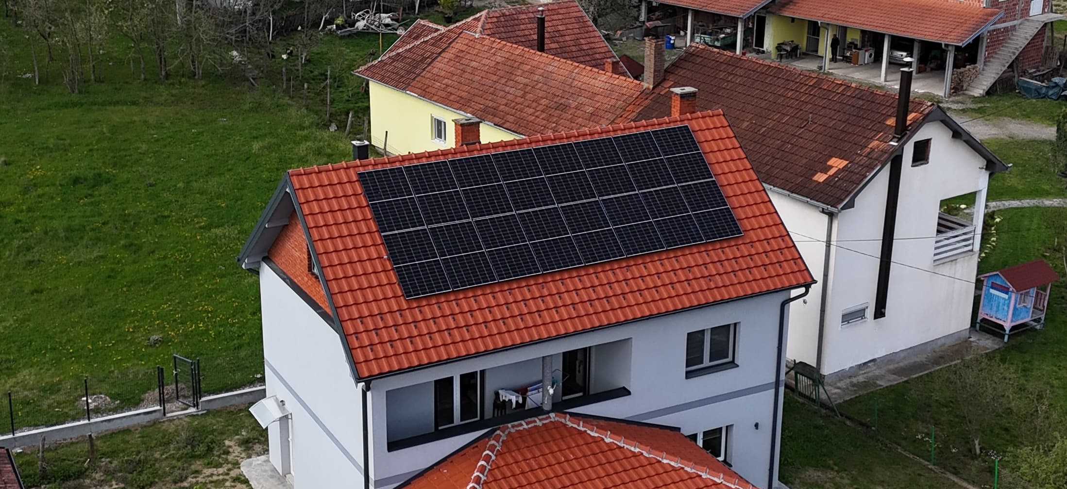 Solarni paneli na crvenom crepnom krovu porodične kuće — referentni 10 kW On-Grid sistem